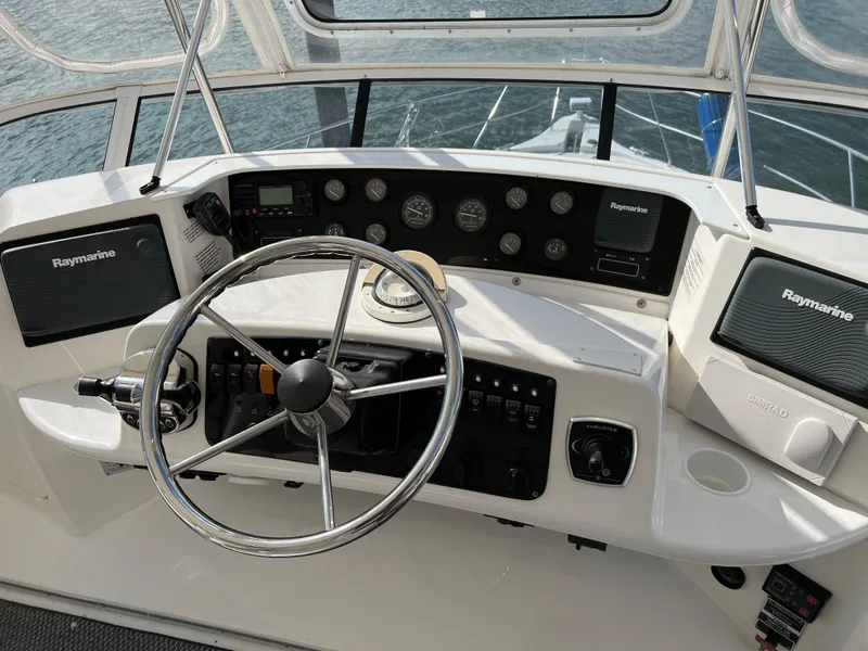 Slide: The Image of 2004 Silverton 39 Motor Yacht helm with Raymarine electronics and steering wheel. - 6