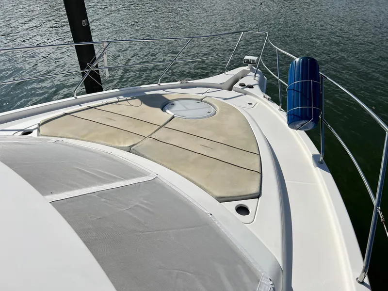 Slide: The Image of 2004 Silverton 39 Motor Yacht bow with sunpad and railing on calm water. - 7