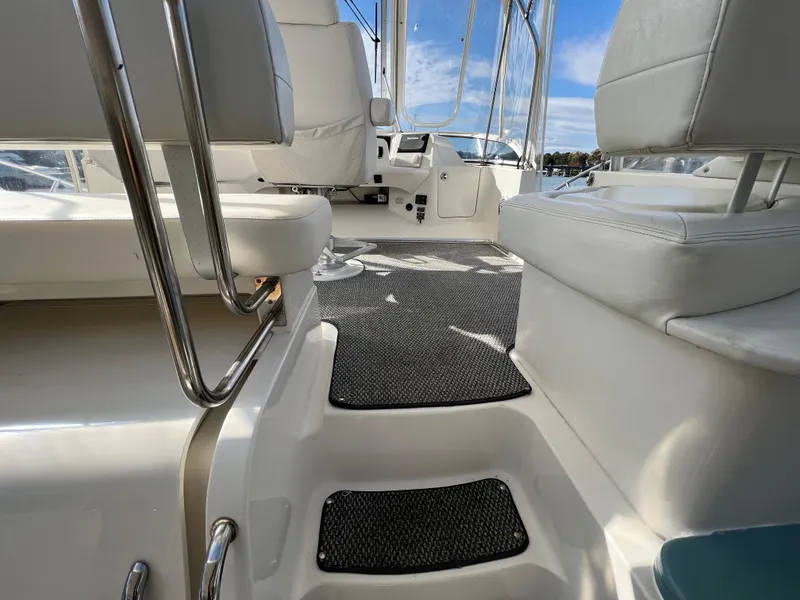 Slide: The Image of Interior view of 2004 Silverton 39 Motor Yacht with white seating and carpeted steps. - 9