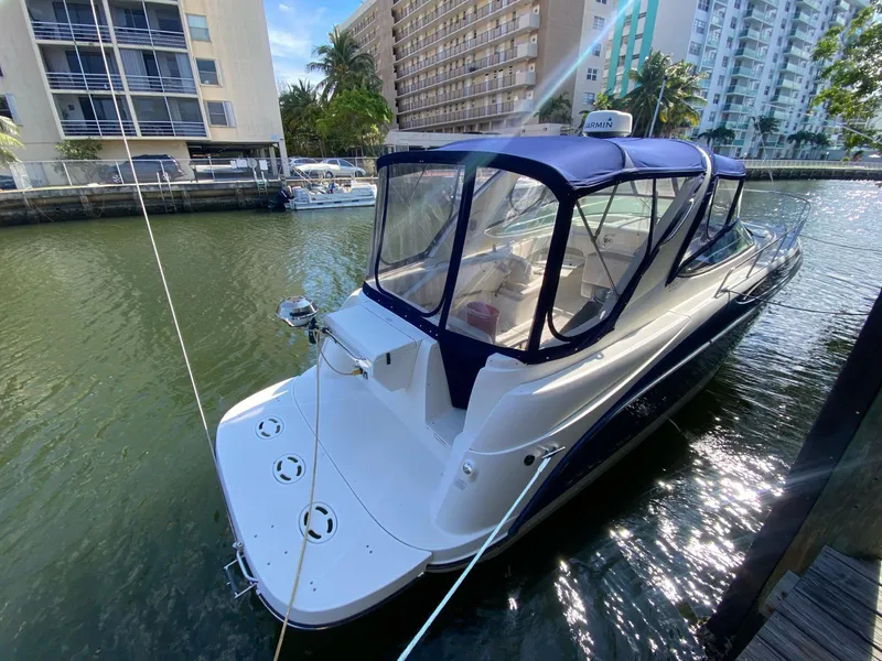 Slide: The Image of 2015 Bayliner 335 Cruiser docked in a marina, featuring a blue canopy. - 2