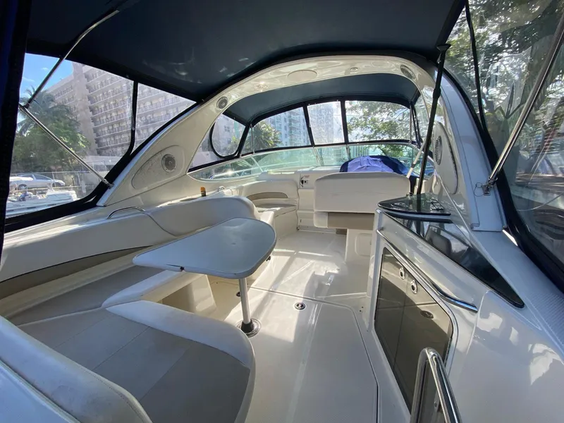 Slide: The Image of 2015 Bayliner 335 Cruiser interior with seating, table, and kitchenette. - 4