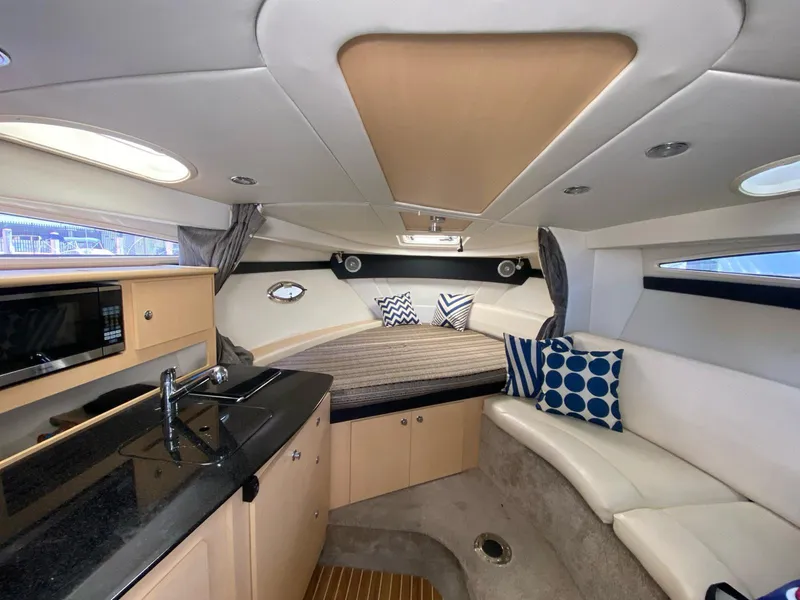 Slide: The Image of 2015 Bayliner 335 Cruiser interior with kitchenette, seating, and modern decor. - 7