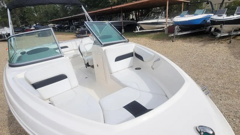 Slide: The Image of 2016 Chaparral 19 H2O Sport boat with white interior, parked outdoors. - 11