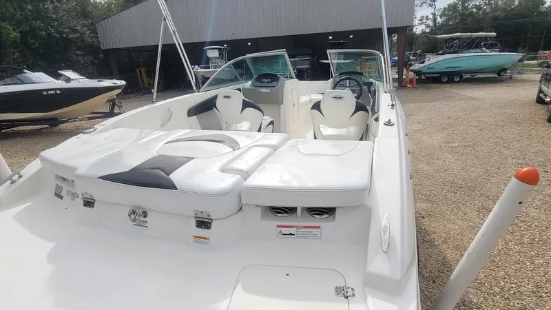 Slide: The Image of 2016 Chaparral 19 H2O Sport boat with white interior, parked outdoors. - 12