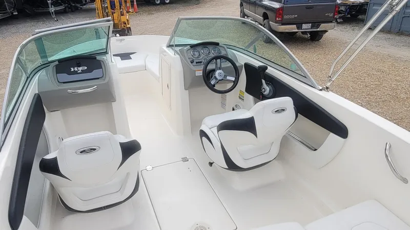 Slide: The Image of 2016 Chaparral 19 H2O Sport boat interior with white seating and steering console. - 14