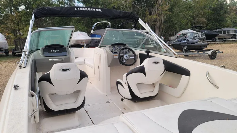 Slide: The Image of 2016 Chaparral 19 H2O Sport boat interior with white seating and steering wheel. - 17