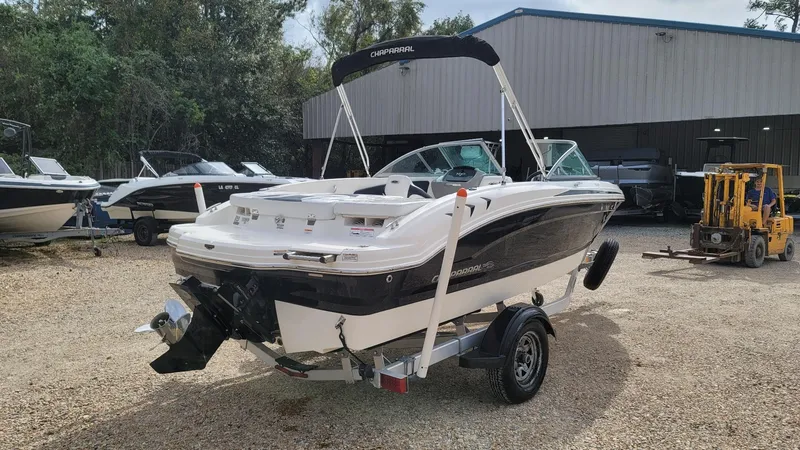 Slide: The Image of 2016 Chaparral 19 H2O Sport boat on trailer, parked outdoors near other boats. - 4