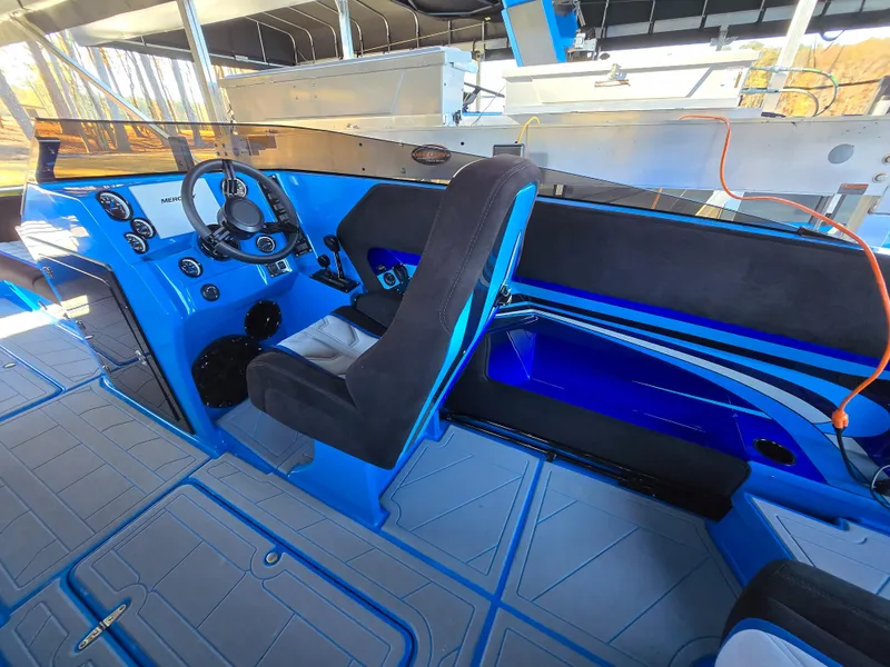 Slide: The Image of 2023 Howard 288 Sport Deck interior with blue accents and modern dashboard. - 51