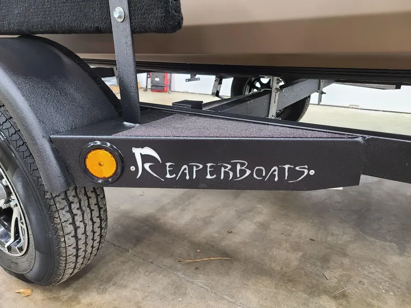 Slide: The Image of Reaper Boats 550 trailer, 2024 model, featuring logo and wheel detail. - 5