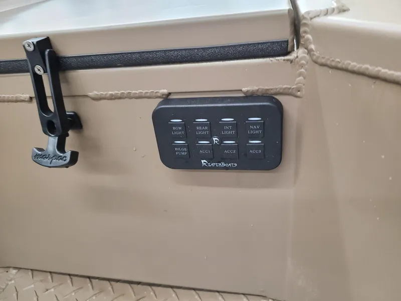 Slide: The Image of Control panel on 2024 Reaper Boats 550, featuring multiple switches and a latch. - 9