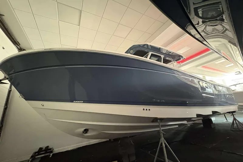 The Image of 2025 Blackfin 302 CC boat in showroom, blue hull, sleek design. - 0