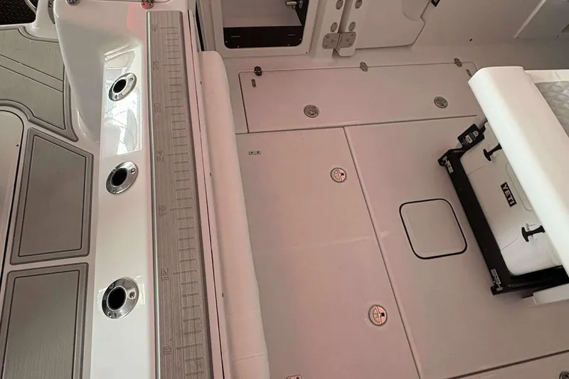 Slide: The Image of 2025 Blackfin 302 CC boat interior with storage compartments and fishing rod holders. - 18