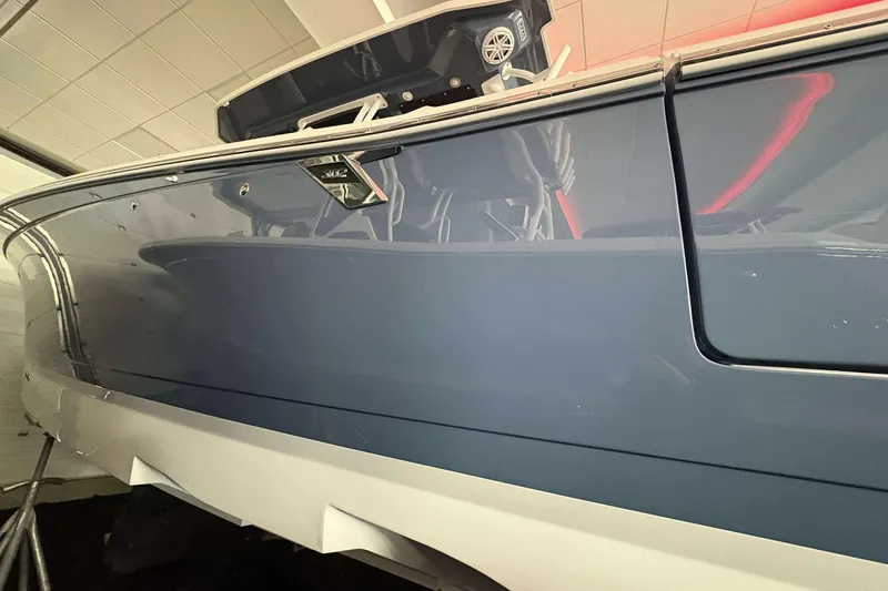 Slide: The Image of 2025 Blackfin 302 CC boat, sleek blue hull, indoor display. - 2