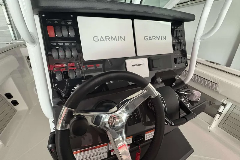 Slide: The Image of 2025 Blackfin 302 CC boat dashboard with Garmin displays and Mercury controls. - 6