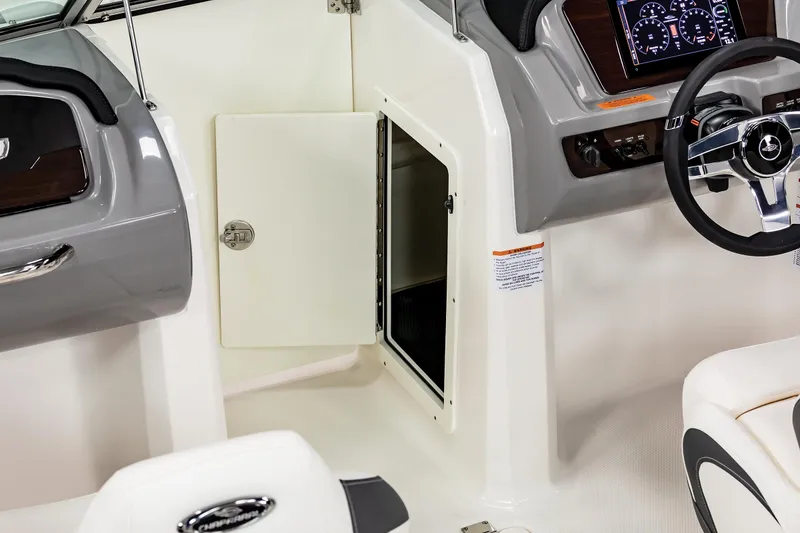 Slide: The Image of 2025 Chaparral SSI boat interior with open storage compartment and modern dashboard. - 19