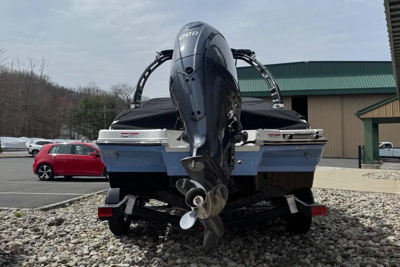 Slide: The Image of 2025 Chaparral SSI boat with powerful outboard motor, parked on rocky terrain. - 3