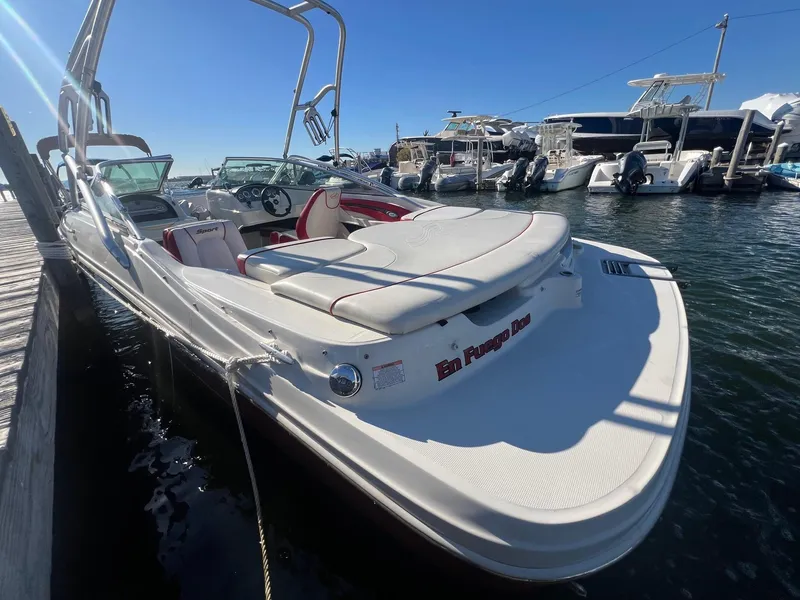 Slide: The Image of 2010 Sea Ray 205 Sport boat docked at marina under clear blue sky. - 2
