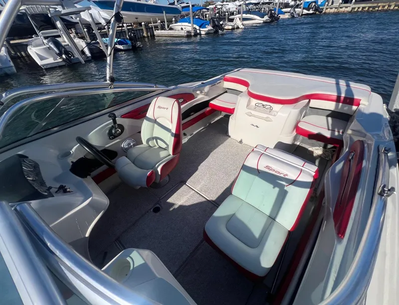 Slide: The Image of 2010 Sea Ray 205 Sport boat interior with red and white seating, docked at marina. - 6