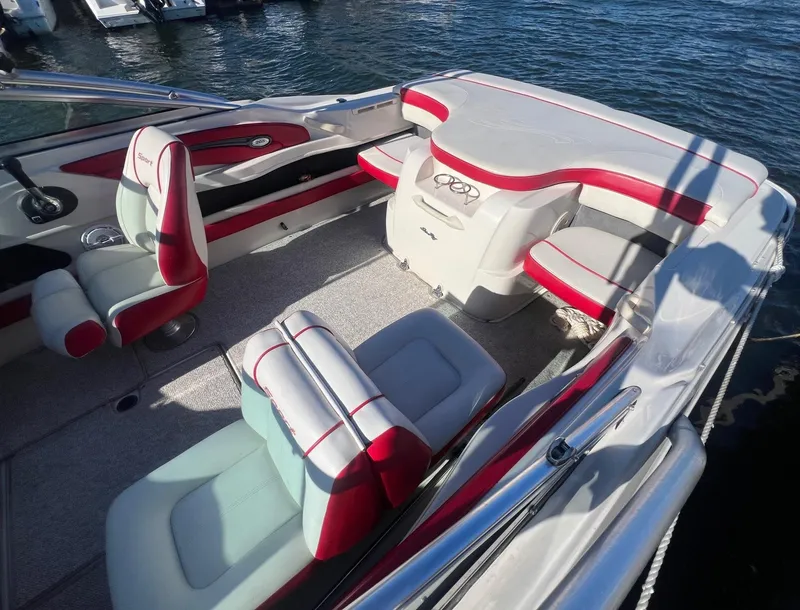 Slide: The Image of 2010 Sea Ray 205 Sport boat interior with red and white seating, docked on water. - 7