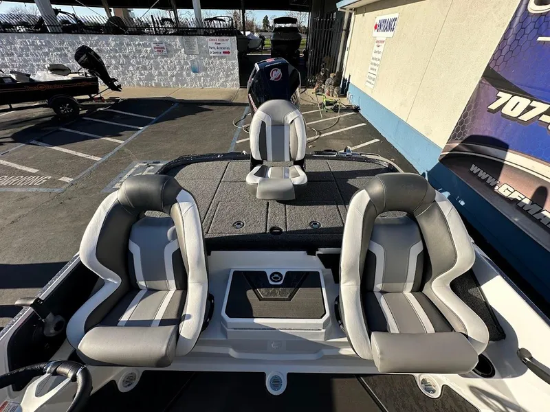 Slide: The Image of 2025 Nitro Z20 XL Pro boat interior with three gray seats in a parking lot. - 11