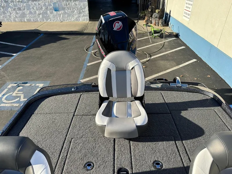 Slide: The Image of 2025 Nitro Z20 XL Pro boat with cushioned seating and outboard motor in parking lot. - 12