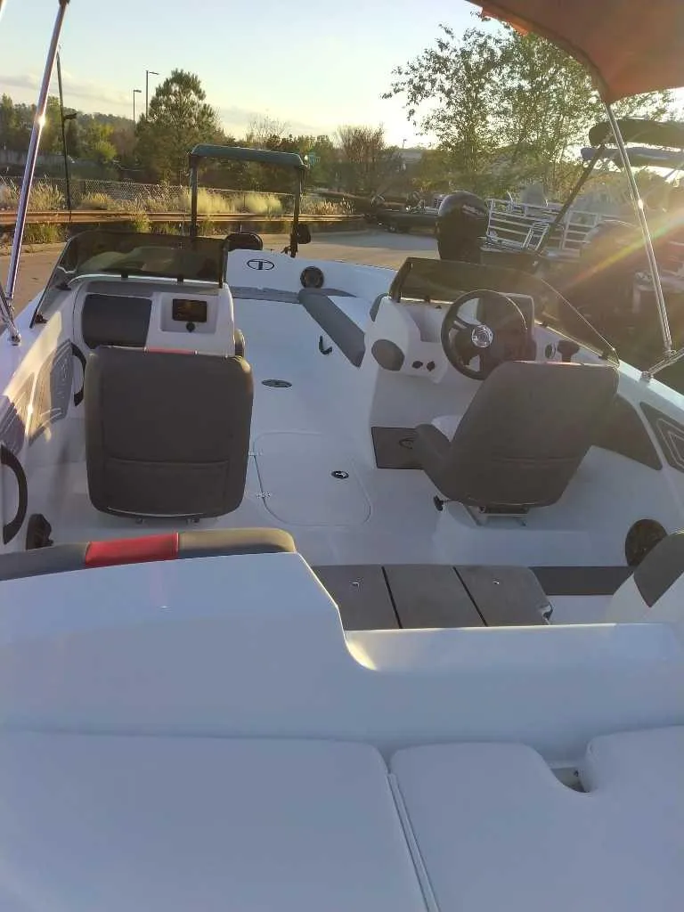 Slide: The Image of 2025 Tahoe T21 boat interior with seating and steering wheel, under a clear sky. - 39