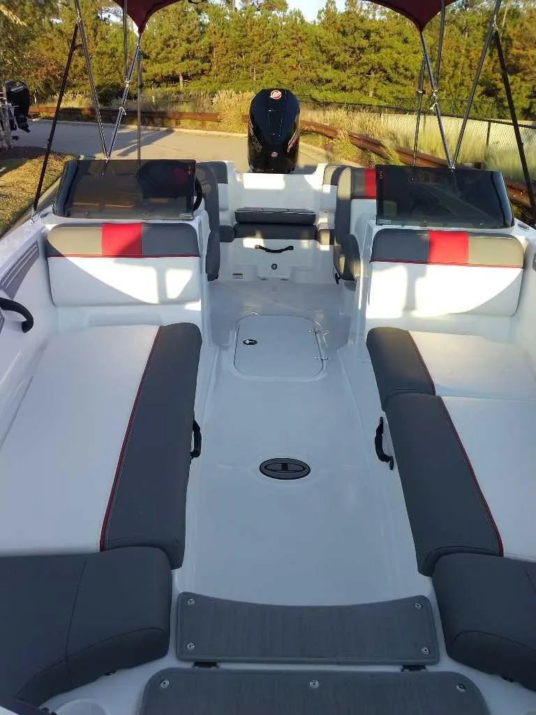 Slide: The Image of 2025 Tahoe T21 boat interior with gray and red seating, open deck layout. - 40