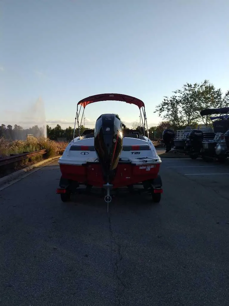 Slide: The Image of 2025 Tahoe T21 boat parked on a road at sunset. - 6