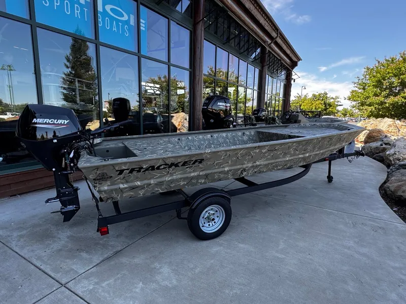 The Image of 2025 Tracker Grizzly 1648 Jon boat with Mercury engine, displayed outside a showroom. - 0