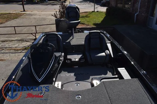Slide: The Image of 2025 Caymas CX 21 PRO boat interior with seating and steering wheel, parked outdoors. - 20