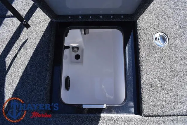 Slide: The Image of 2025 Caymas CX 21 PRO boat storage compartment, gray carpet, Thayer's Marine logo. - 36