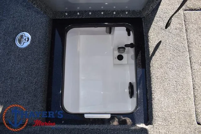 Slide: The Image of 2025 Caymas CX 21 PRO boat storage compartment with gray carpet and latch. - 37