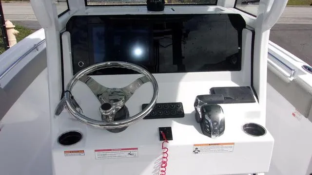 Slide: The Image of 2025 Sportsman Heritage 231 boat console with steering wheel and controls. - 7