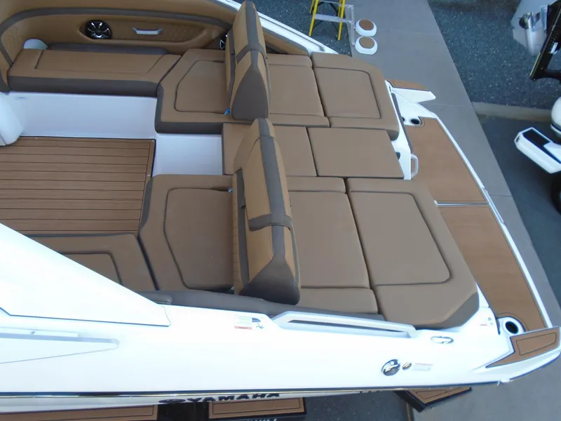 Slide: The Image of 2025 Yamaha Boats 275SD interior with brown cushioned seating and teak flooring. - 24