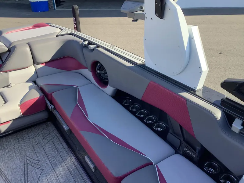 Slide: The Image of 2019 Supra SL450 boat interior with gray and red seating, cup holders, and speaker. - 14