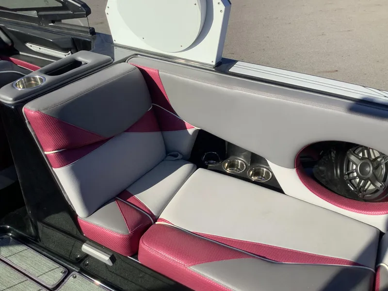Slide: The Image of 2019 Supra SL450 boat interior with gray and red seating, cup holders, and speaker. - 17