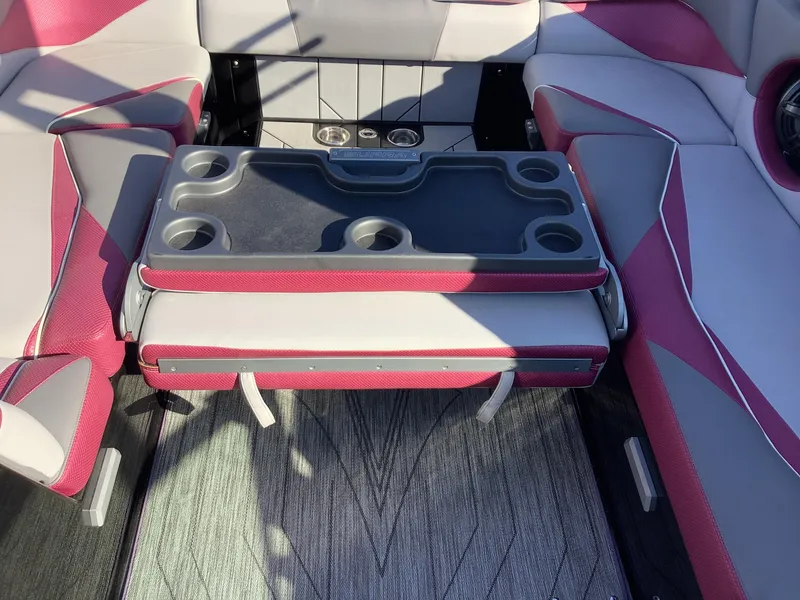 Slide: The Image of 2019 Supra SL450 boat interior with red and gray seating and a foldable table. - 26
