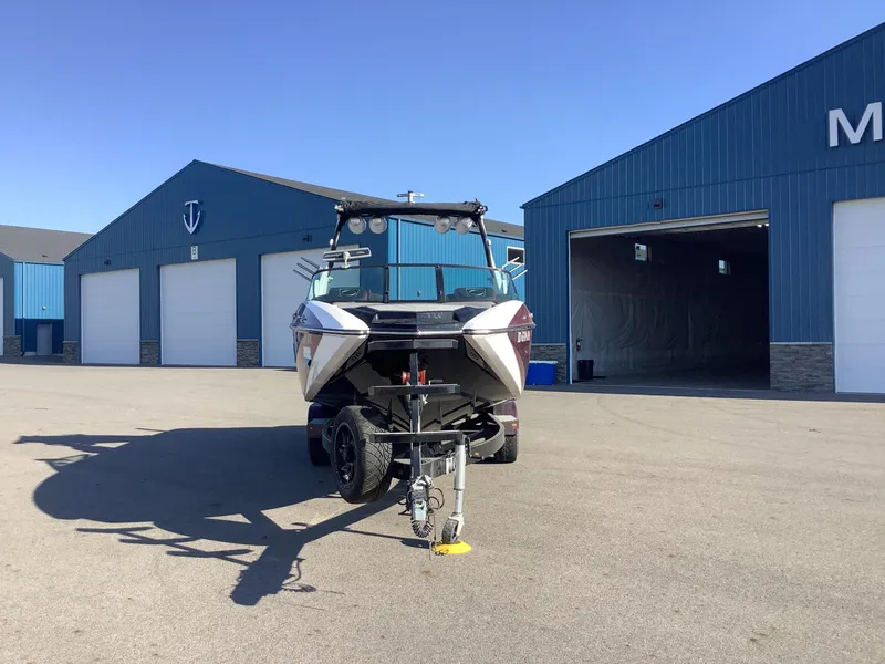 Slide: The Image of 2019 Supra SL450 boat on trailer in front of blue storage buildings. - 3