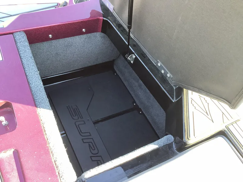 Slide: The Image of Open storage compartment in 2019 Supra SL450 boat, featuring carpeted interior and hydraulic lift. - 31