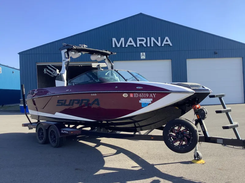 Slide: The Image of 2019 Supra SL450 boat on trailer outside marina building. - 5