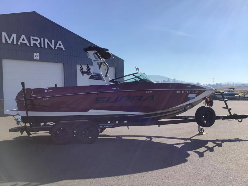 Slide: The Image of 2019 Supra SL450 boat on trailer outside marina. - 6