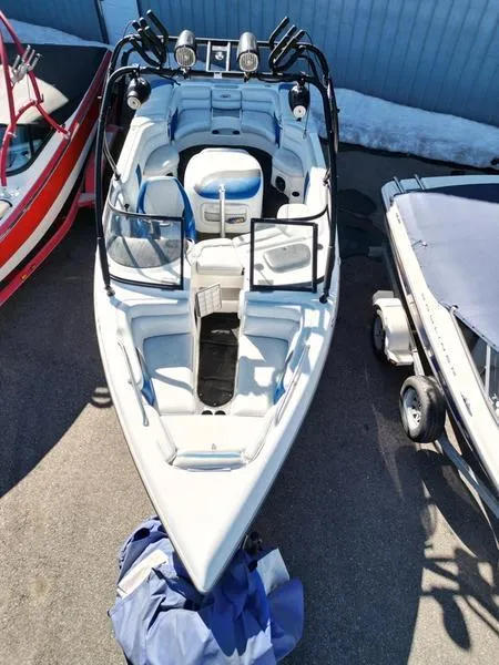 Slide: The Image of 2002 Tigé 22i boat, aerial view, parked between two other boats. - 11