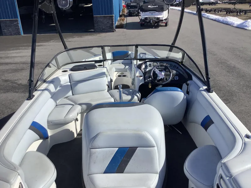 Slide: The Image of 2002 Tigé 22i boat interior with white and blue seating, steering wheel, and dashboard. - 12