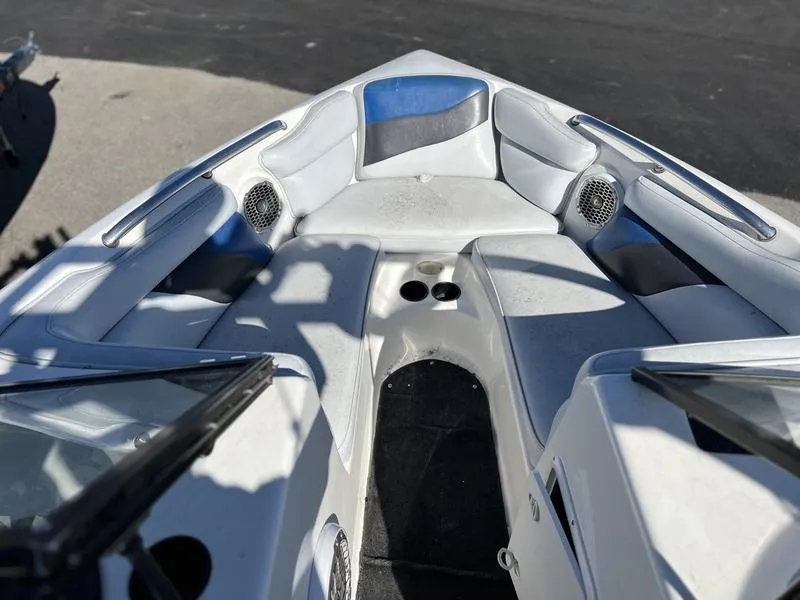 Slide: The Image of 2002 Tigé 22i boat interior with white seating and cup holders. - 22