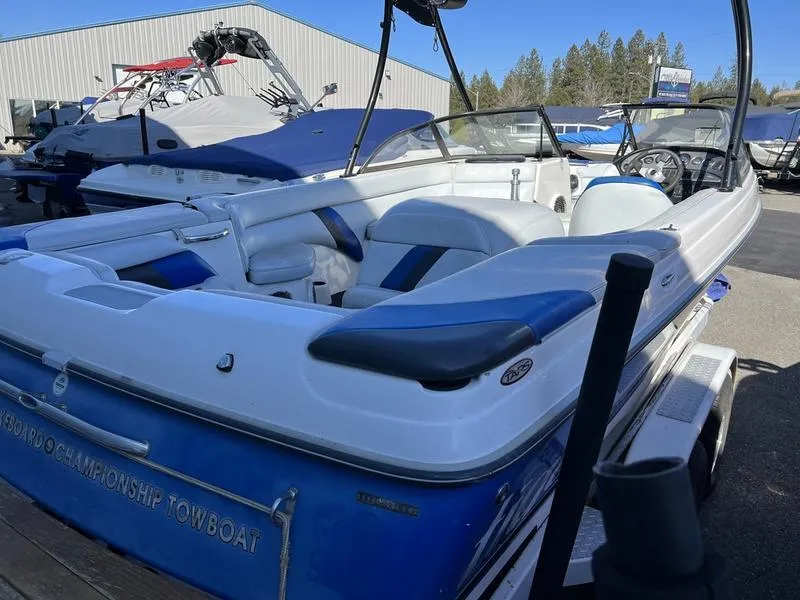 Slide: The Image of 2002 Tigé 22i boat with blue and white interior, parked outdoors. - 23