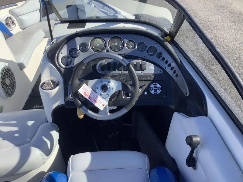 Slide: The Image of 2002 Tigé 22i boat dashboard with steering wheel and control panel. - 25