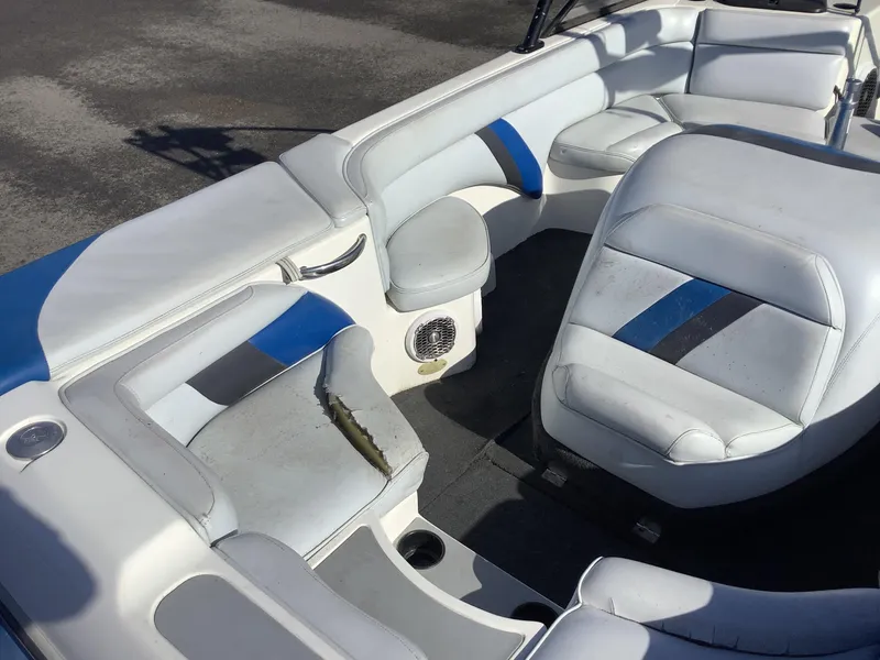 Slide: The Image of 2002 Tigé 22i boat interior with white and blue seating, showing wear and tear. - 31