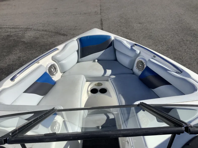 Slide: The Image of 2002 Tigé 22i boat interior with blue and gray seating, cup holders, and speakers. - 32