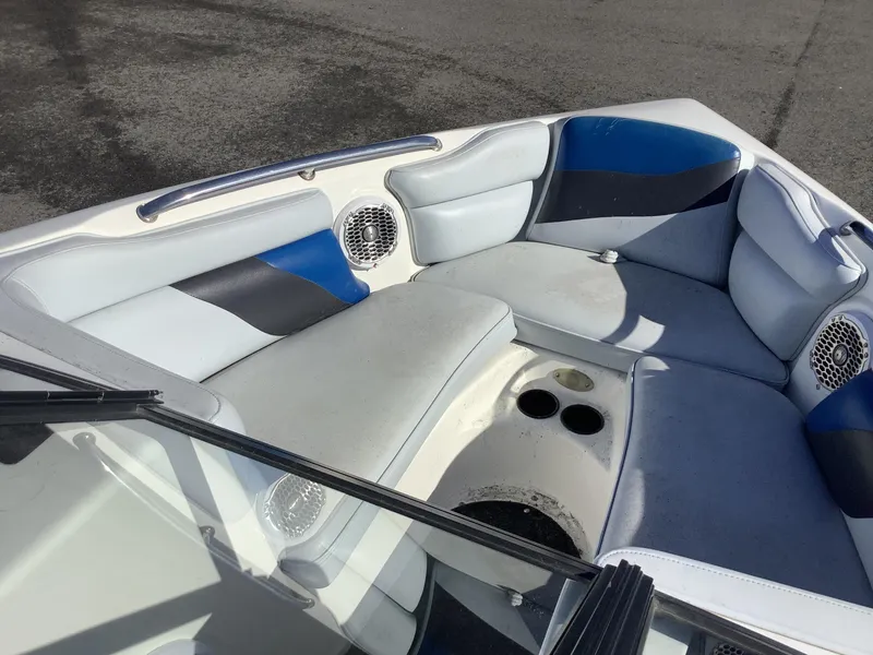 Slide: The Image of 2002 Tigé 22i boat interior with blue and gray seating, cup holders, and speakers. - 34