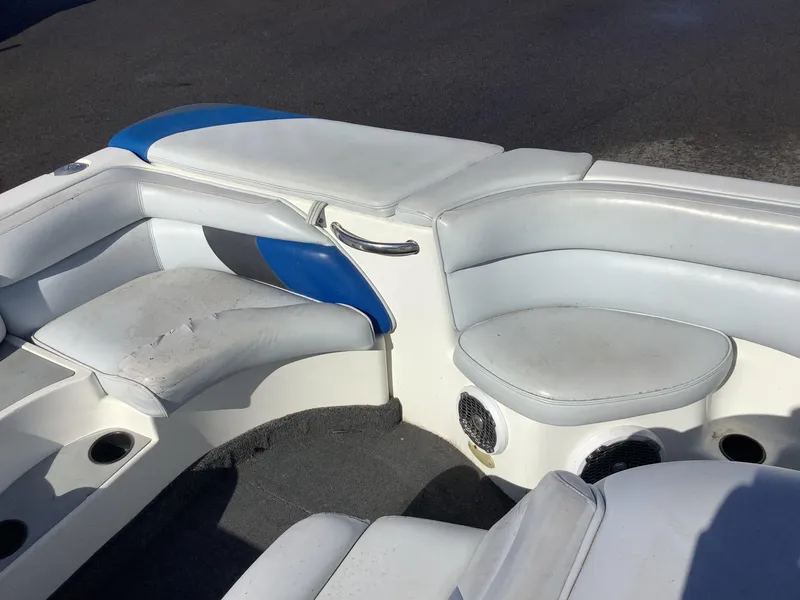Slide: The Image of 2002 Tigé 22i boat interior with white and blue seating, cup holders, and speakers. - 36
